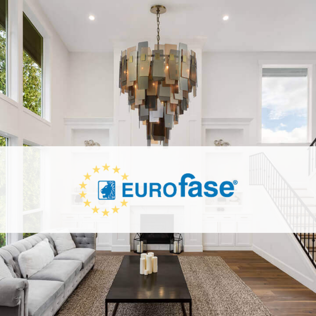 Eurofase statement chandelier with layered geometric panels in a bright modern living room featuring high ceilings, white walls, and a grey tufted sofa